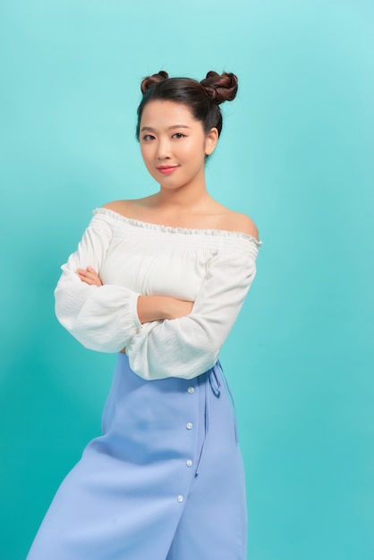 Teenager girl over blue wall keeping the arms crossed