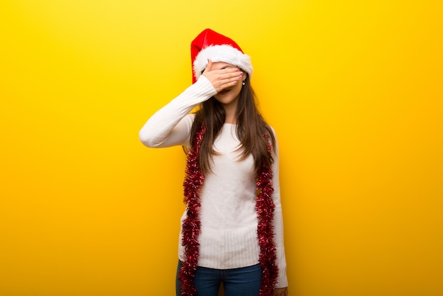 Teenager girl celebrating christmas holidays covering eyes by hands