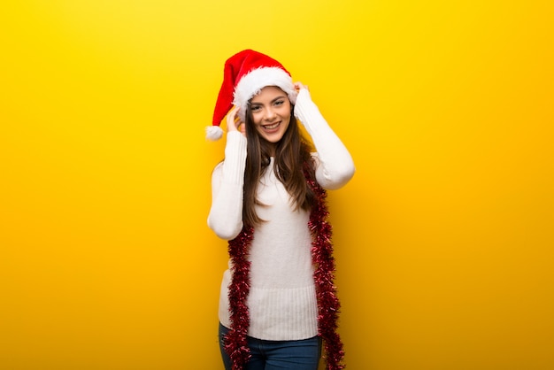 Teenager girl celebrating christmas holidays on vibrant yellow background