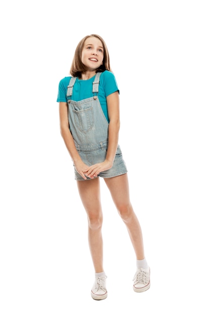 A teenager girl in denim overalls and a blue tank top emotionally jumps up. . Vertical.