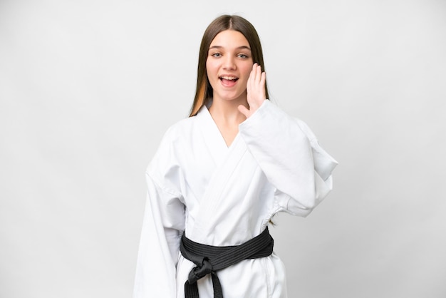 Teenager girl doing karate over isolated white background with surprise and shocked facial expression