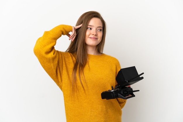 Teenager girl holding a drone remote control over isolated white background