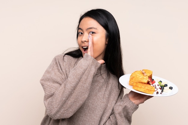 Teenager girl holding plate with waffles