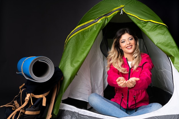 Teenager girl inside a camping green tent