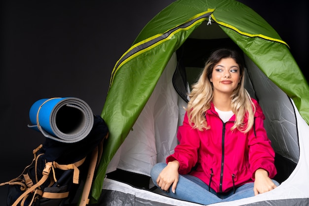 Foto ragazza adolescente all'interno di una tenda da campeggio verde