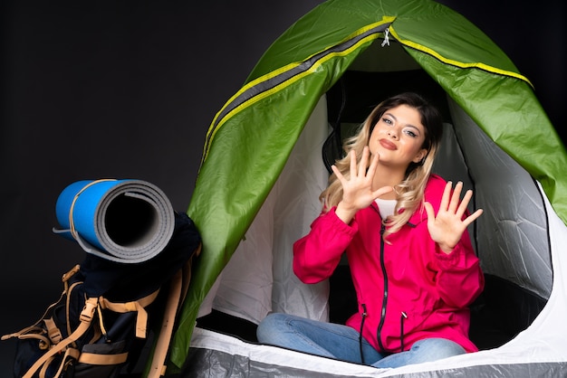 Foto ragazza adolescente all'interno di una tenda da campeggio verde