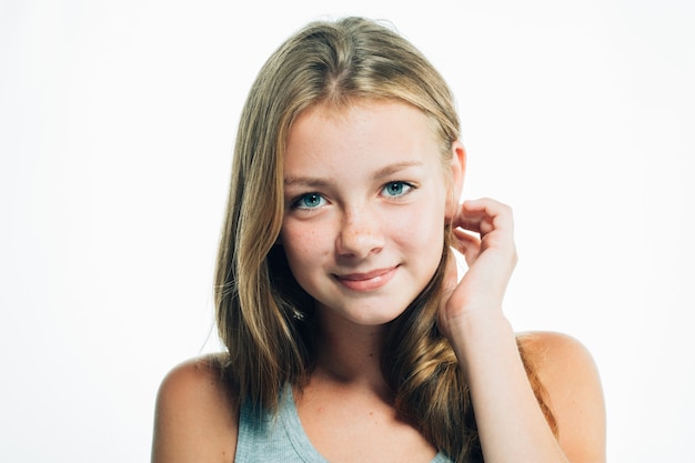 Teenager girl is touching herself hair. Portrait of woman female with freckles face. Studio shot.