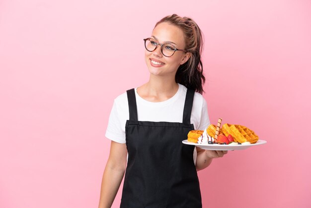 Teenager girl isolated on pink background sending a message or email with the mobile