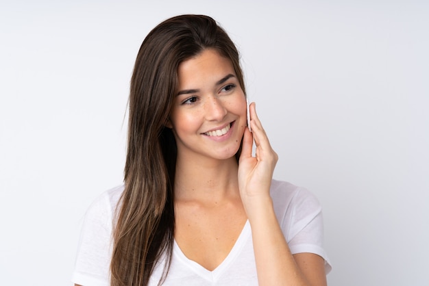 Teenager girl over isolated wall with cotton pad for removing makeup from her face