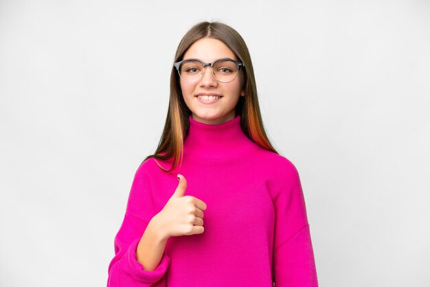 親指を立てるジェスチャーを与える孤立した白い背景の上のティーンエイ ジャーの女の子
