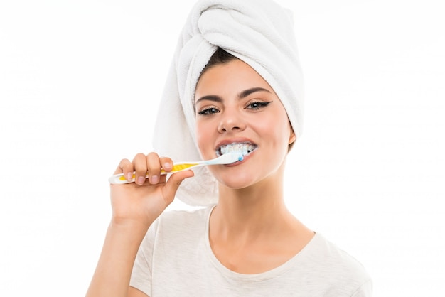 Teenager girl over isolated white wall brushing her teeths