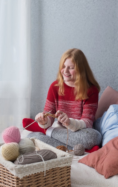 Teenager girl  knits at home