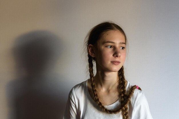 Teenager girl looking away against wall