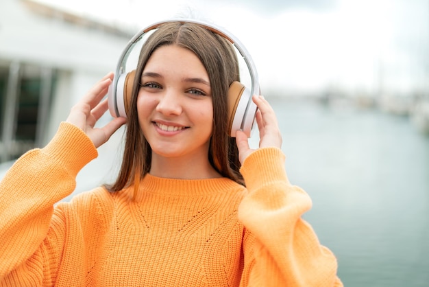 Teenager girl at outdoors listening music