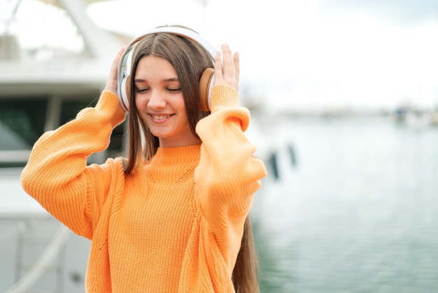 Teenager girl at outdoors listening music