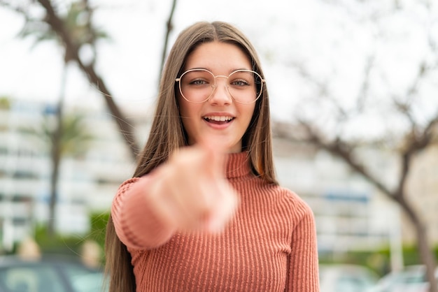 Foto la ragazza dell'adolescente all'aperto ha sorpreso e che indica la parte anteriore