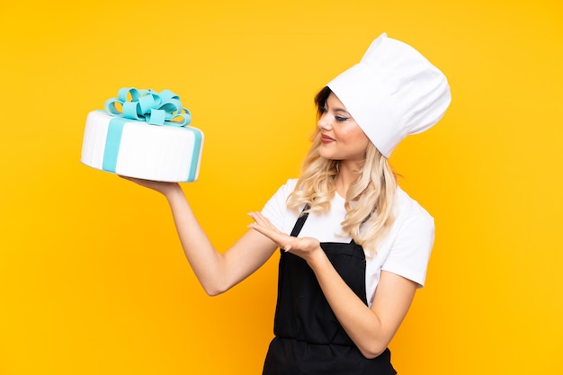 Teenager girl pastry holding a big cake