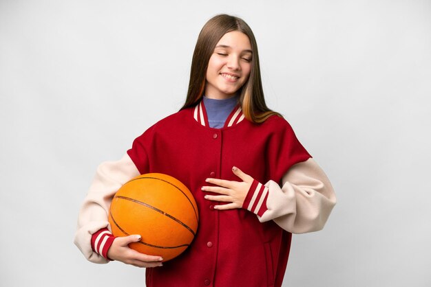 Teenager girl playing basketball over isolated white background smiling a lot