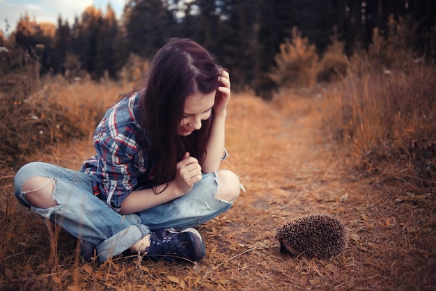 teenager girl playing with a hedgehog