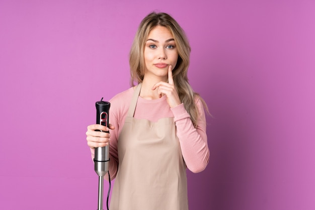 Teenager girl using hand blender