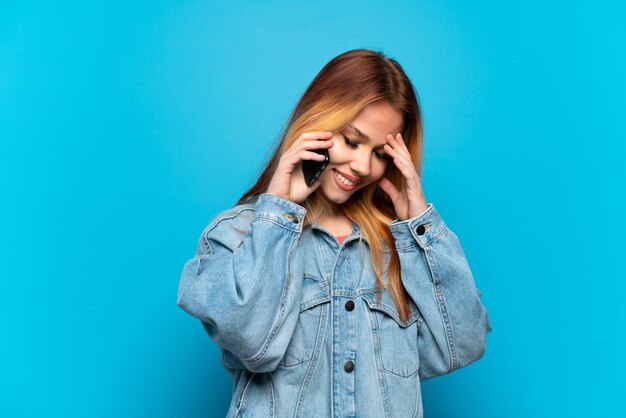 Teenager girl using mobile phone isolated background laughing