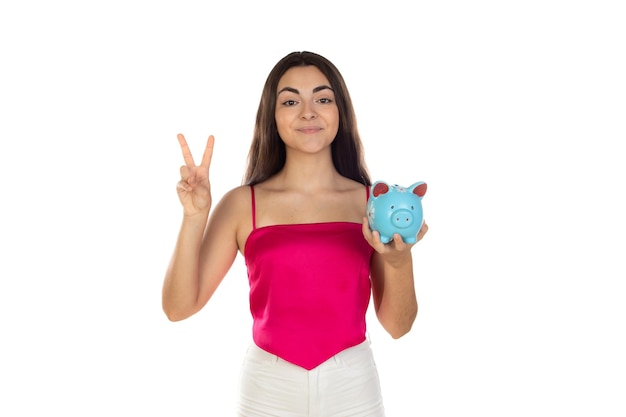 Teenager girl wearing pink top standing with piggy bank money box