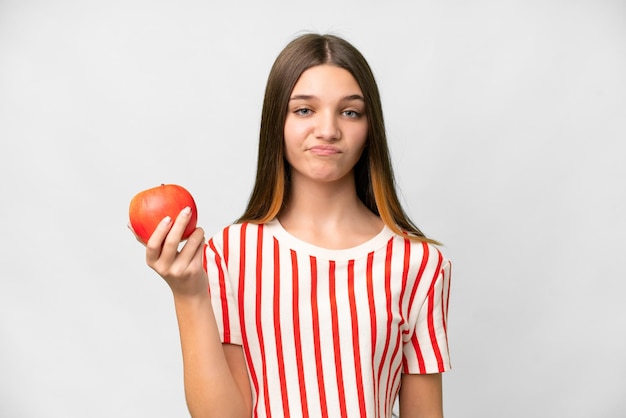 Девушка-подросток с яблоком на изолированном белом фоне с грустным выражением лица