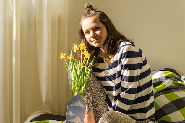 Teenager girl with bouquet of yellow spring flowers