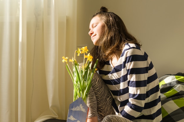 Teenager girl with bouquet of yellow spring flowers