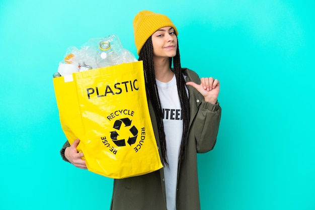 Teenager girl with braids holding a bag to recycle proud and selfsatisfied