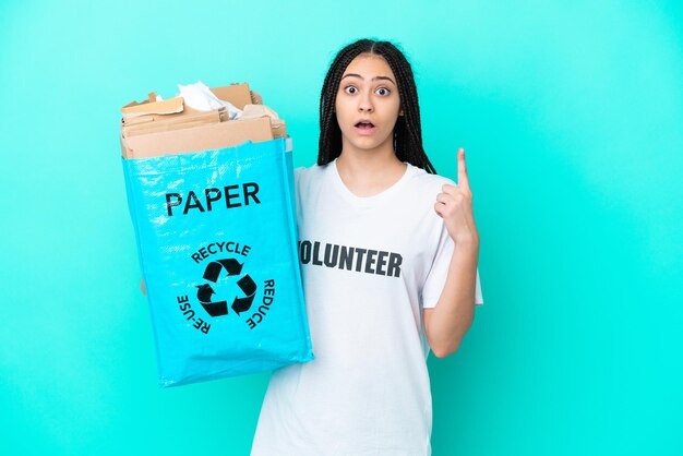 Teenager girl with braids holding a bag to recycle thinking an idea pointing the finger up