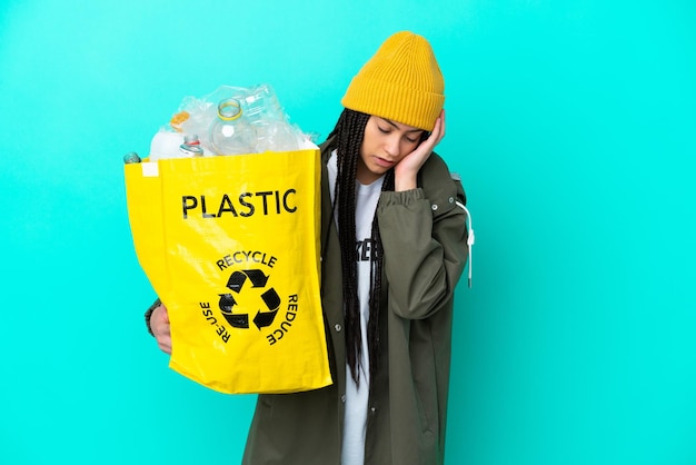 Teenager girl with braids holding a bag to recycle with headache