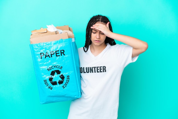 Teenager girl with braids holding a bag to recycle with headache