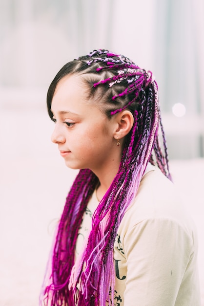 Teenager girl with bright, colorful Afro braids Zizi