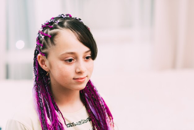 Teenager girl with bright, colorful Afro braids Zizi