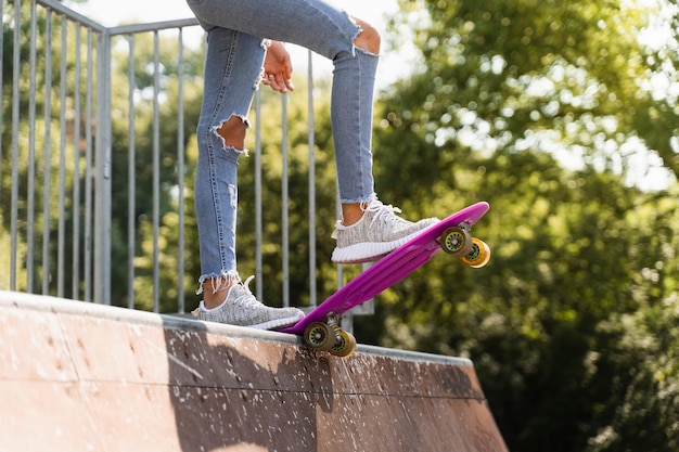 Teenager girl with penny board ready to go down on skateboard park playground Sport equipment Extreme lifestyle