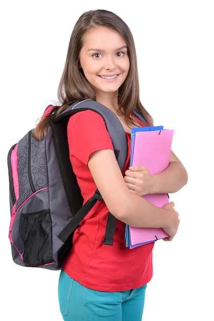 Teenager girl with school backpack holding colored folders.