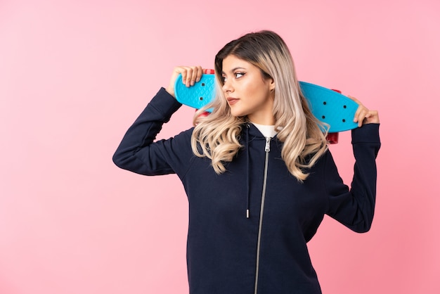 Teenager girl with skate and looking side