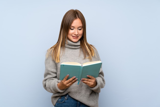 Teenager girl with sweater and reading a book