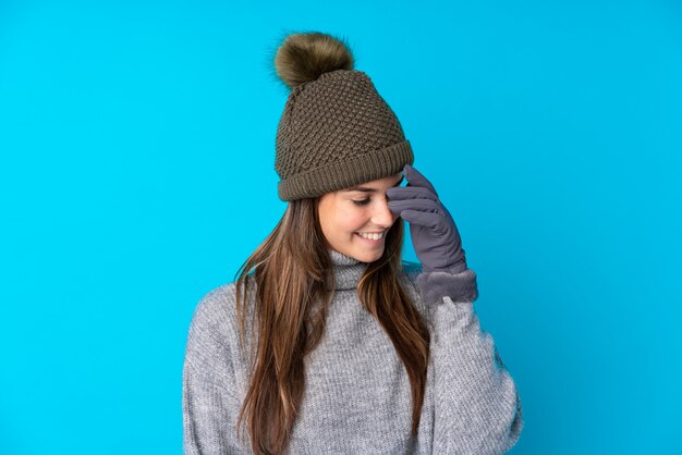 Foto ragazza dell'adolescente con il cappello di inverno sopra la parete blu