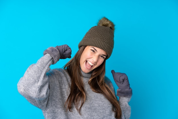 Teenager girl with winter hat celebrating a victory