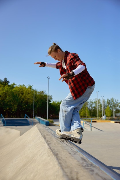Teenager guy with roller skates performing tricks outdoors. Inline skating exercise and extreme sports practice