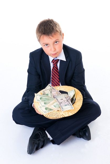 A teenager holding a hat and begging.