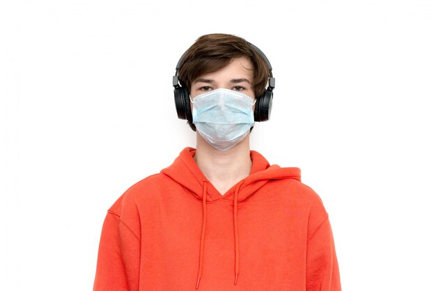 Teenager at home schooling in a medical mask and with a backpack isolated during coronovirus.