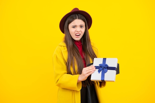 Teenager kid with present box teen girl giving birthday gift\
present greeting and gifting concept angry face upset emotions of\
teenager girl