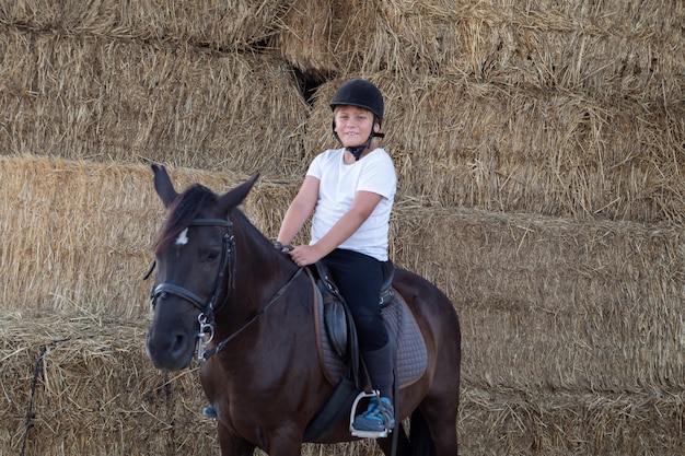 Teenager learning to ride in the riding school