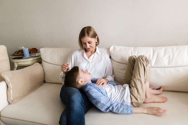 Teenager lies on the lap of an adult woman she strokes his head