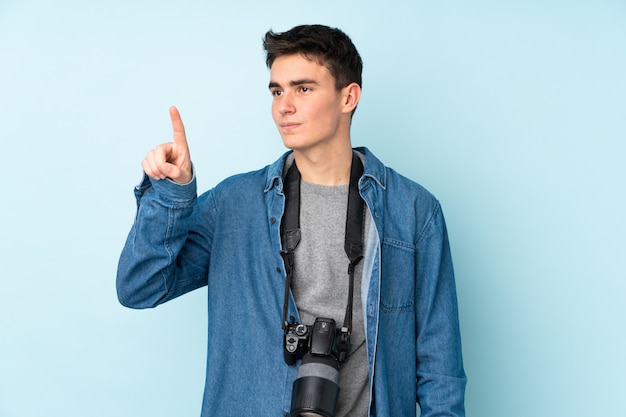 Teenager photographer man on blue wall touching on transparent screen