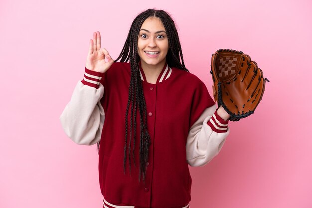 Teenager player with baseball glove isolated on pink background showing ok sign with fingers