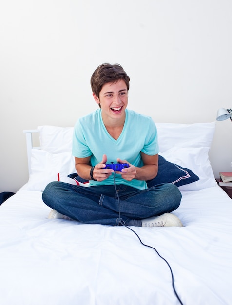 Teenager playing video games on his bed